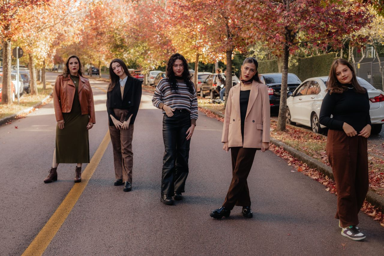 services-03 Group of women posing on a city street with autumn foliage, showcasing fashion.